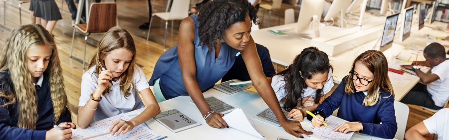 Teacher female black looking down at papers on a table